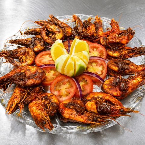 Platón de camarones bañados en salsa de chipotle, con jitomate, cebolla y limón al centro