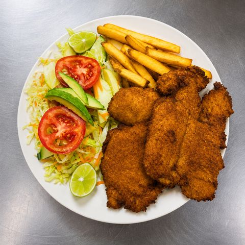Plato con filetes de pescado empanizados, papas a la francesa y ensalada con aguacate